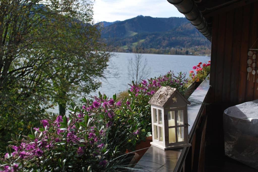 ein Vogelhaus auf der Seite eines Hauses mit Blumen in der Unterkunft Sonniges Appartement am Tegernsee in Gmund am Tegernsee