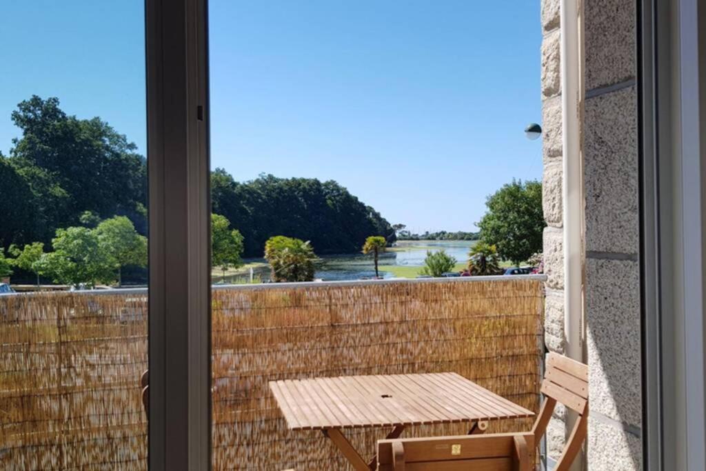 d'un balcon avec une table et une vue sur l'eau. dans l'établissement Bel appartement la Forêt-Fouesnant vue sur la baie, à La Forêt-Fouesnant