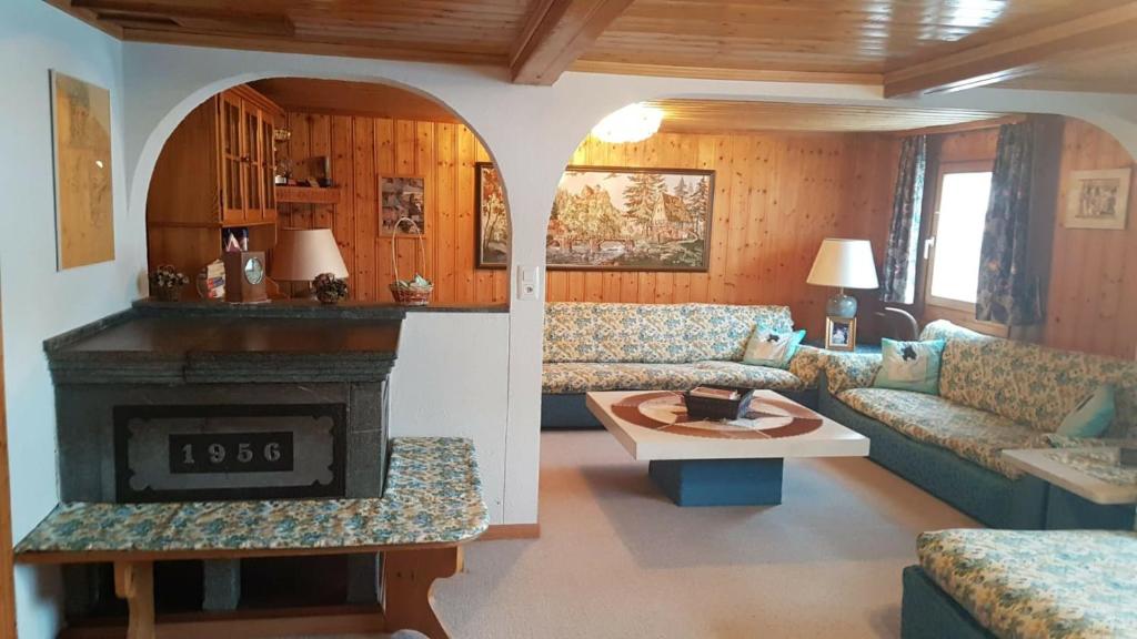 a living room with a couch and a fireplace at Walser Chalet Casa Paterna in Disentis