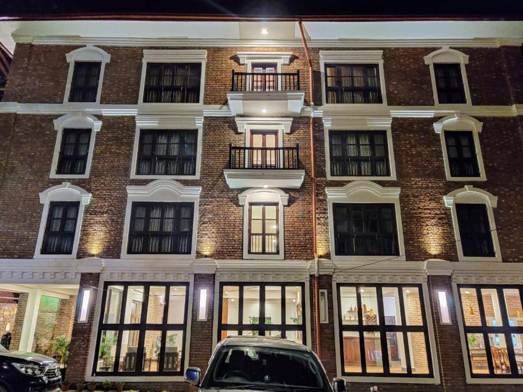 a large brick building with a car parked in front of it at Bandipur Village Inn in Bandipur