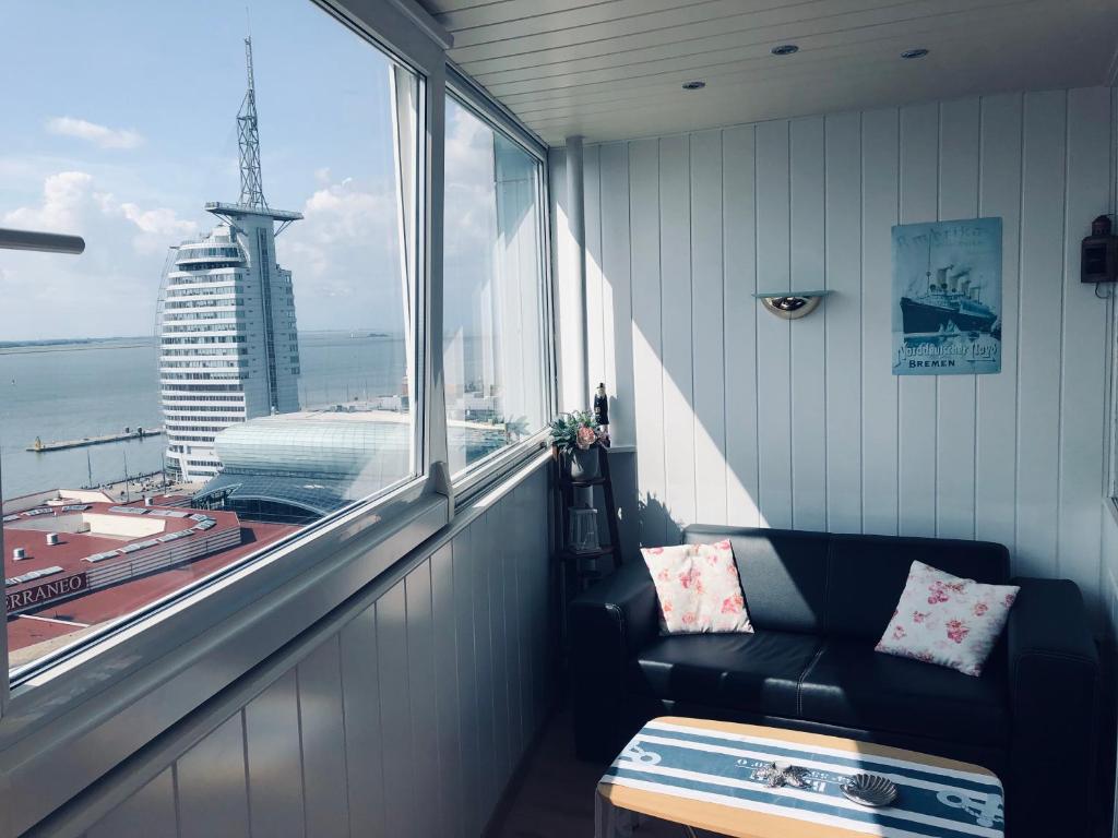ein Zimmer mit einem Sofa und einem großen Fenster in der Unterkunft Apartment Meerblick in Bremerhaven