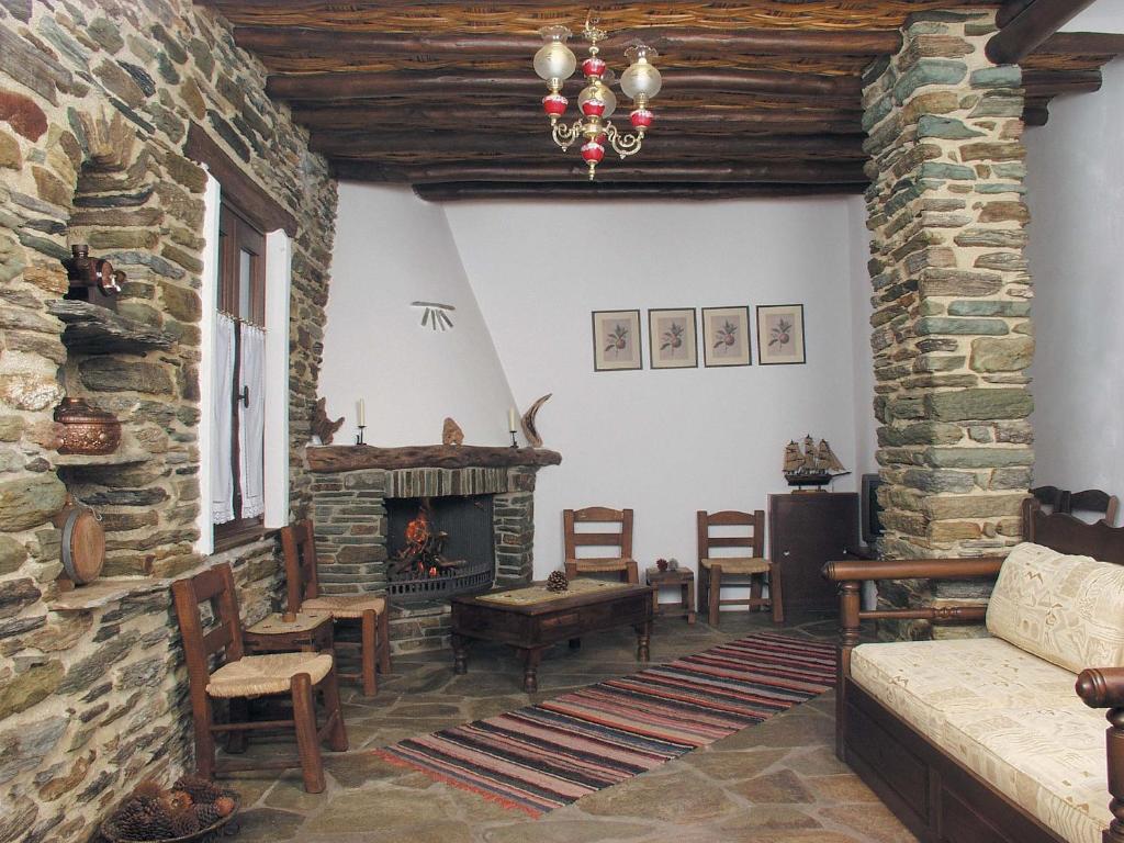 a living room with a stone fireplace and a couch at Anastasia Luxury Villas in Gavrio