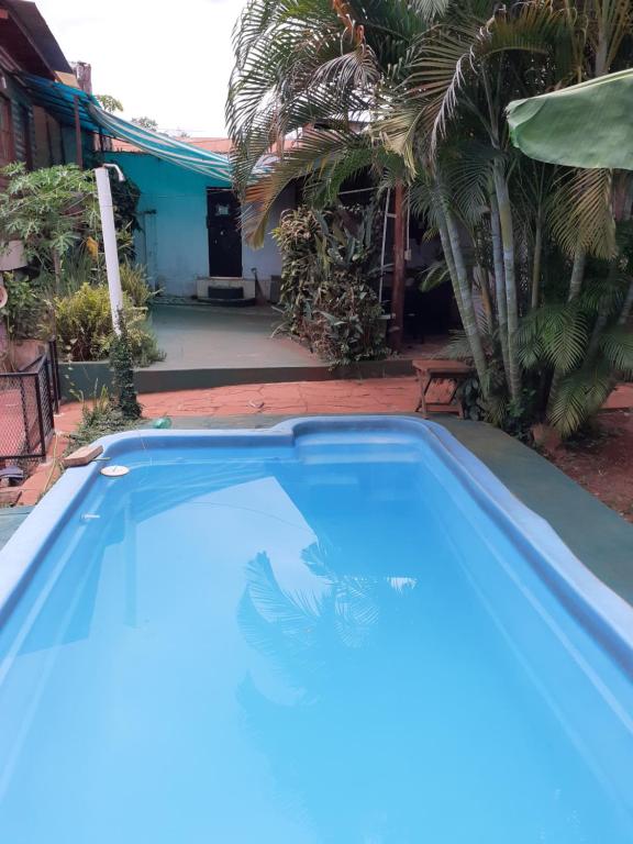 a blue swimming pool in front of a house at Complejo Remitur in Puerto Iguazú