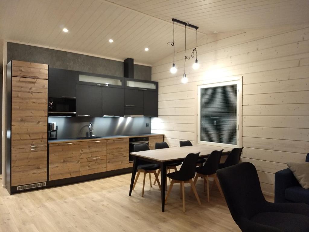 a kitchen and dining room with a table and chairs at Louhi A in Äkäslompolo