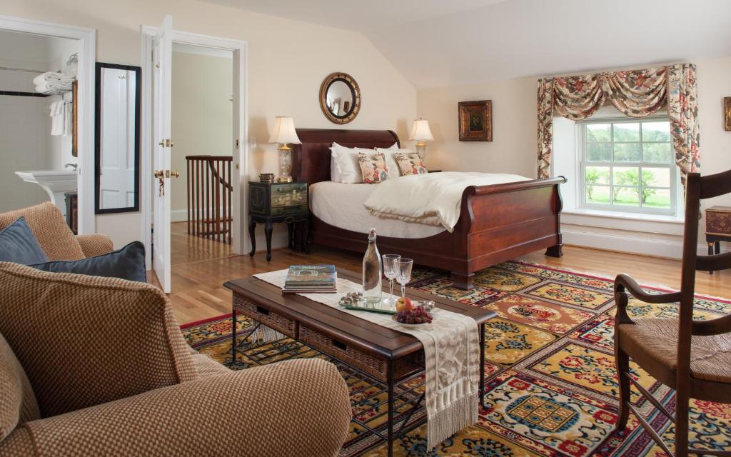 a bedroom with a bed and a coffee table at Inn at Warner Hall in Gloucester
