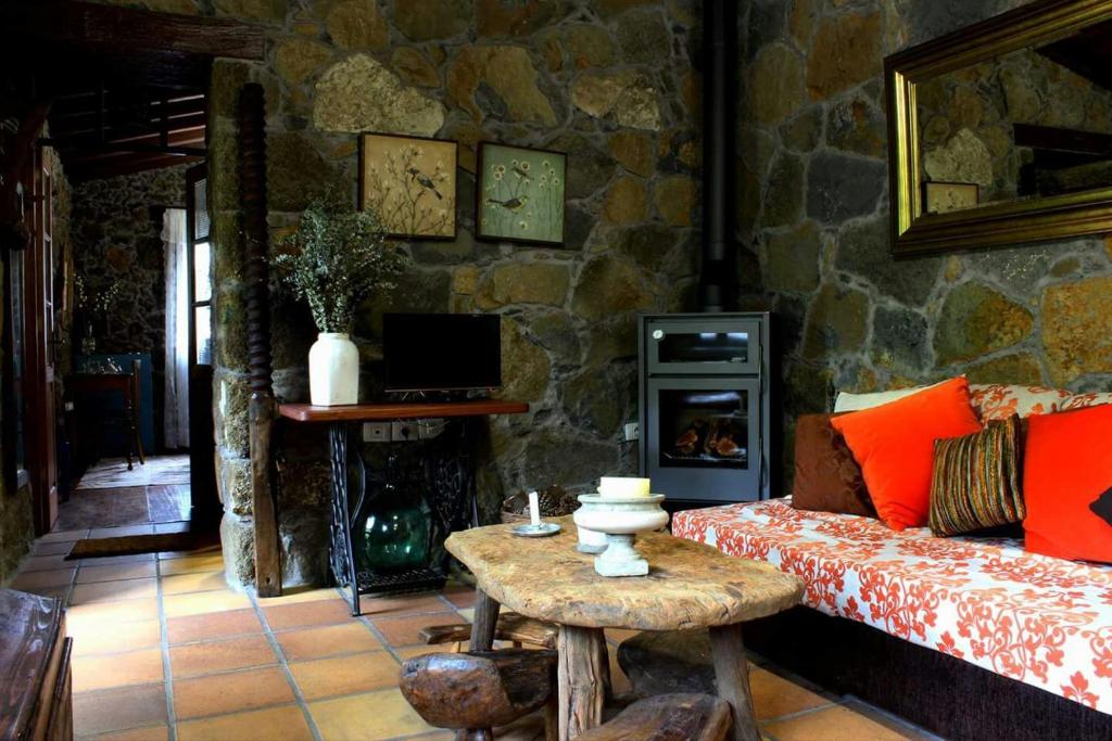 - un salon avec un canapé et un mur en pierre dans l'établissement CASA MARY LOLA, à Tiñor