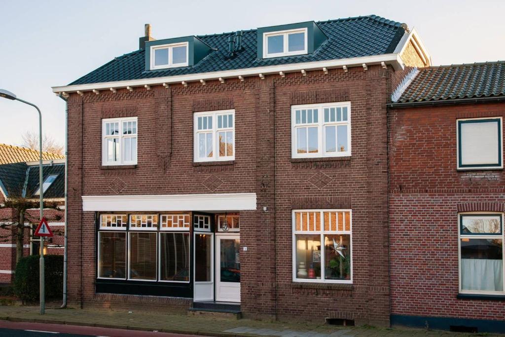 a red brick building with white windows on a street at The Farmer's Daughter in Venray