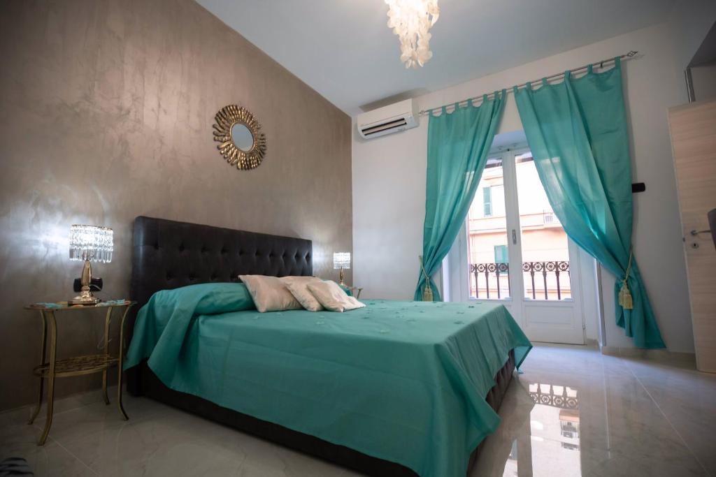 um quarto com uma cama com um cobertor azul e uma janela em New In!Amalie at Santa Lucia em Nápoles