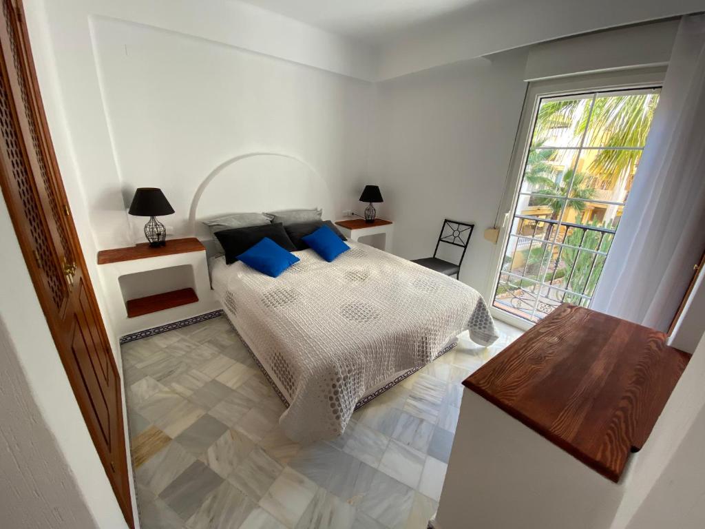 トレビエハにあるApartamento Tranquilo, Aldea del Marのベッドルーム1室(青い枕のベッド1台、窓付)
