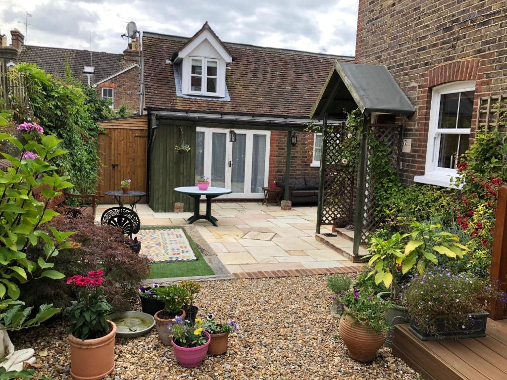 a garden with potted plants and a patio at Kristina's Coach House in Horsham