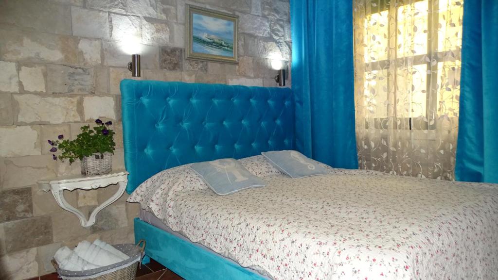 a blue bed with a blue headboard in a bedroom at Apartament - Lisa in Budva
