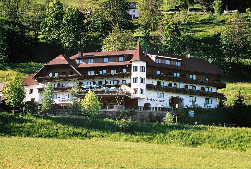 ein großes Gebäude auf einem Hügel auf einem Feld in der Unterkunft Hotel Restaurant Stigenwirth in Krakauebene