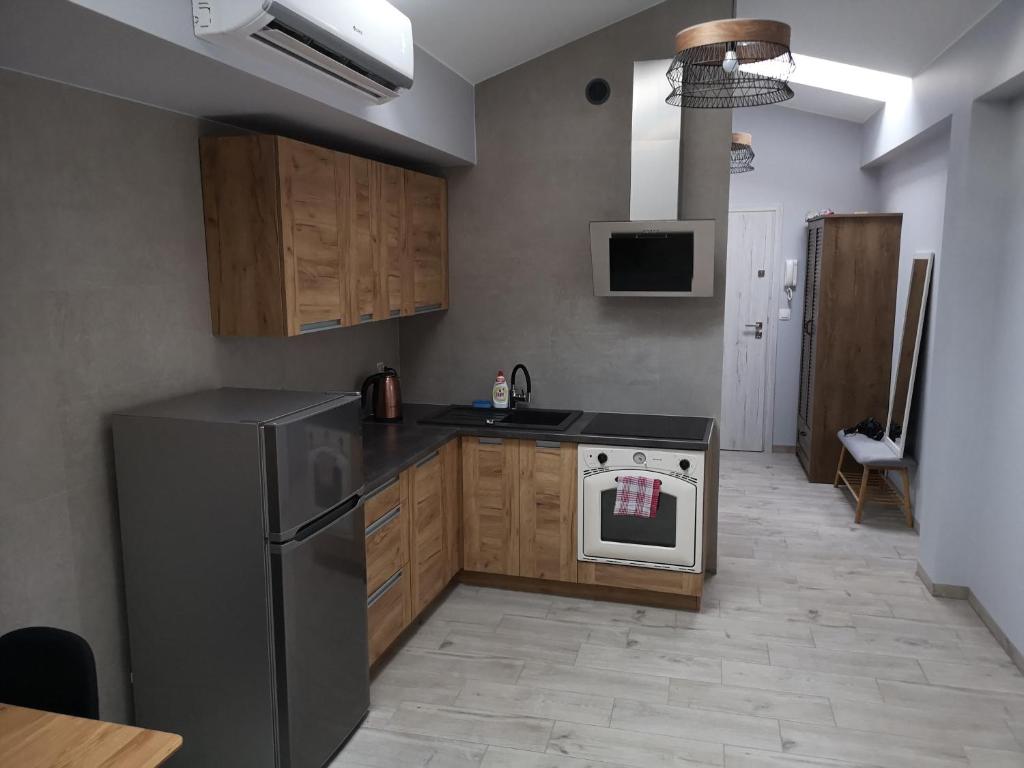 a kitchen with a black refrigerator and a stove at Apartamenty Rynek in Września