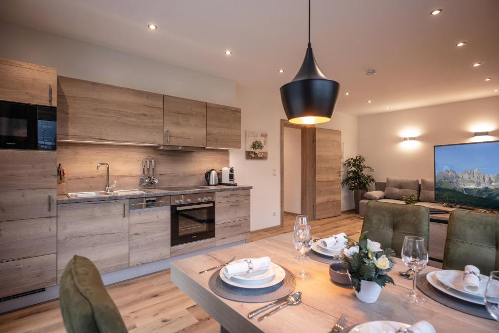 a kitchen and dining room with a wooden table at APART deluxe am Wilden Kaiser in Söll