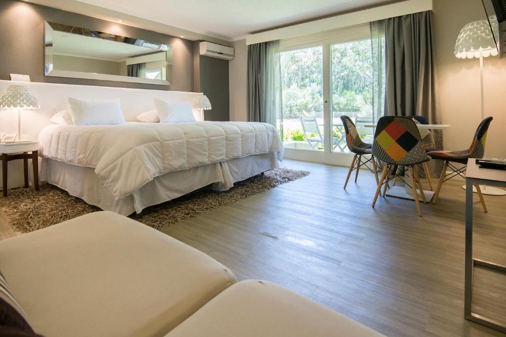 Punta del Este, Forest Lagoon, Luxury في بونتا دل إستي: غرفة نوم بسرير كبير وطاولة وكراسي
