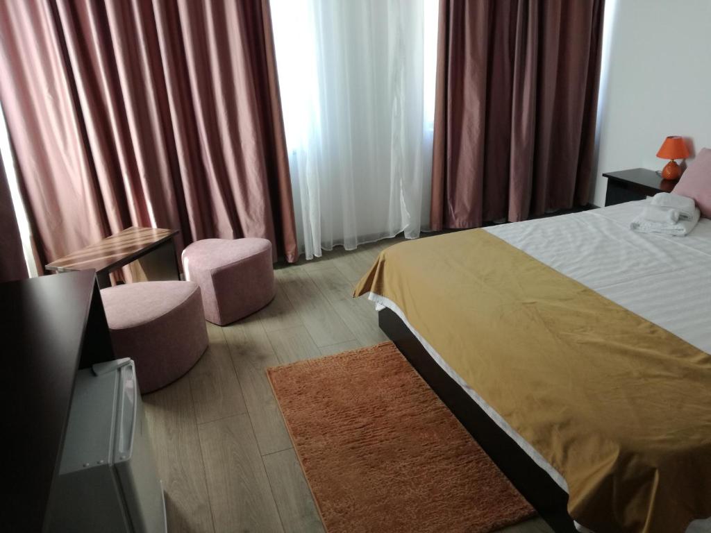 una camera d'albergo con letto, tavolo e sedie di Stella Maris a Techirghiol