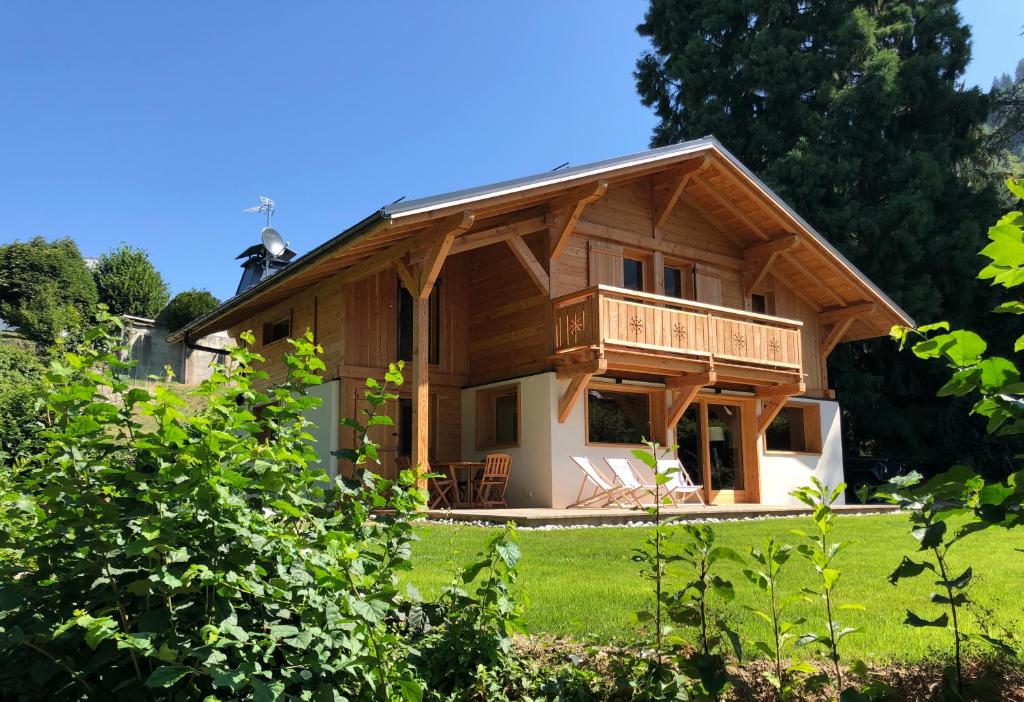 ein großes Holzhaus mit Balkon auf einem Feld in der Unterkunft Prestigious Chalet in Saint-Gervais-les-Bains