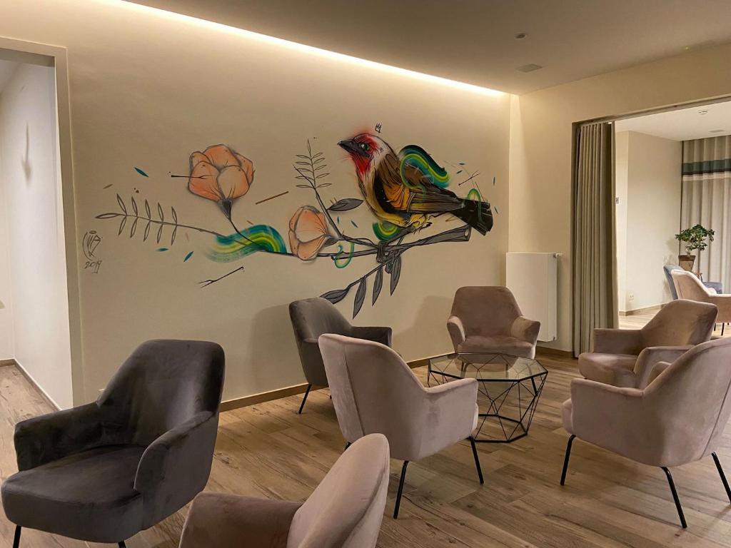 una sala de espera con sillas y aves pintadas en la pared en Hotel Beau Site en Francorchamps