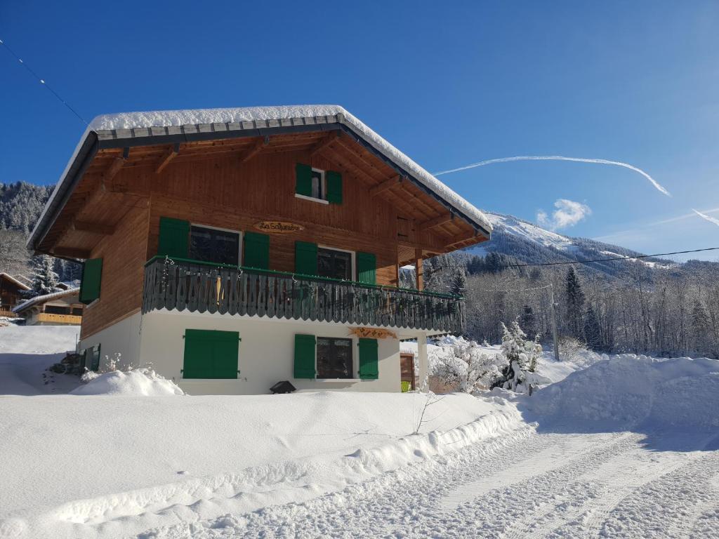 une maison dans la neige avec une montagne en arrière-plan dans l'établissement Chalet la sapiniere, à La Chapelle-dʼAbondance