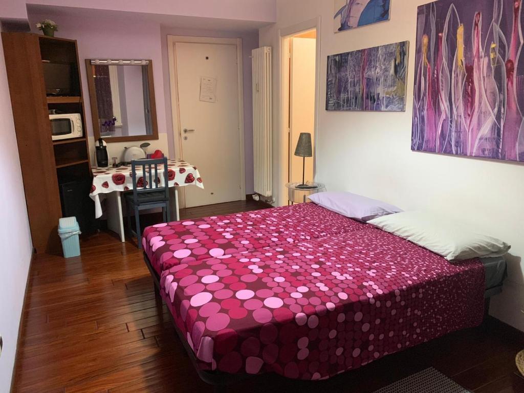 - une chambre avec un lit et une couverture rose dans l'établissement BREAD & BUTTER, à Rome