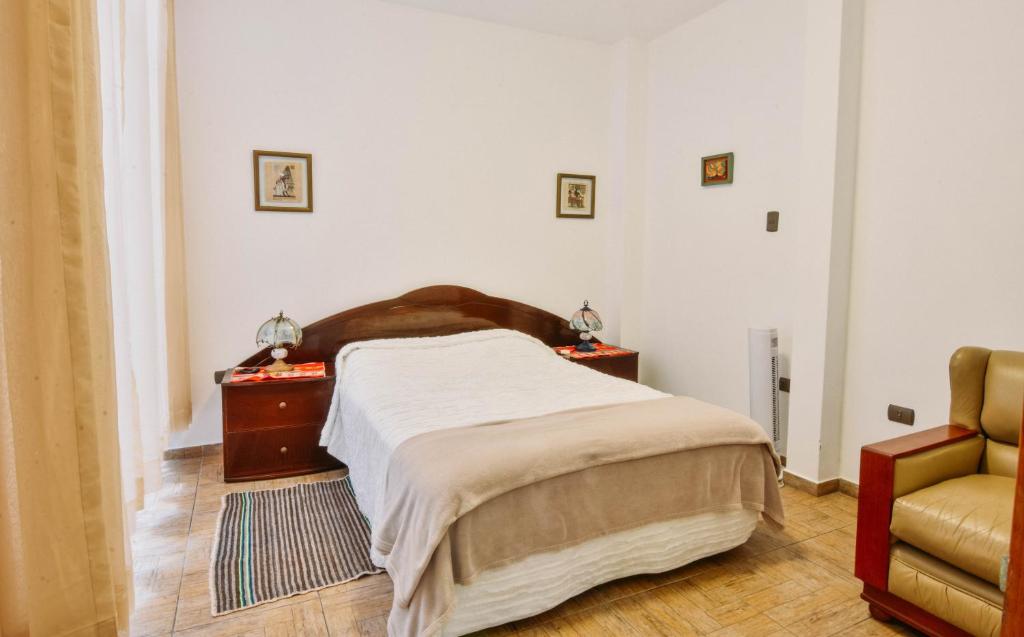 sypialnia z łóżkiem i krzesłem w obiekcie Apartment Acogedor w mieście Huanchaco