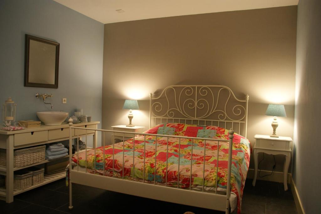 1 dormitorio con 1 cama, lavamanos y 2 lámparas en B&B Van Hunebed Naar Jullie Bed en Schoonoord