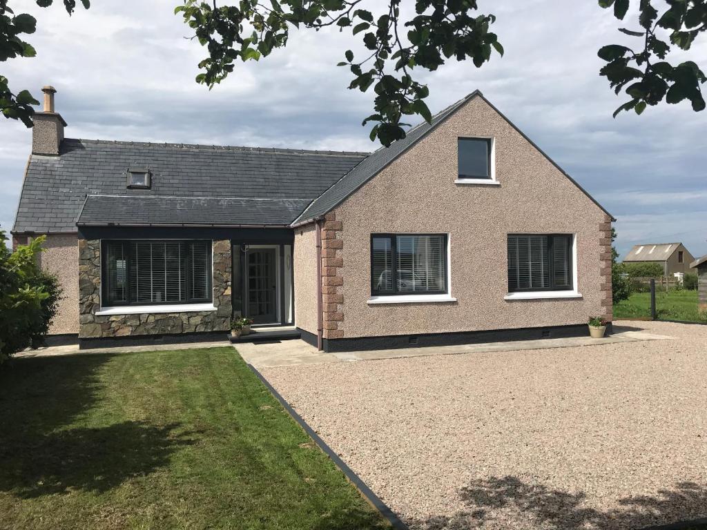 a large brick house with a driveway at CROFT 14 SWORDALE in Swordale