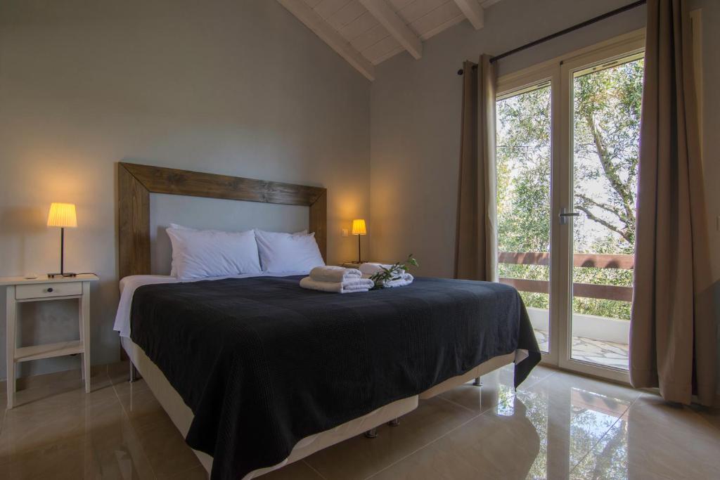 a bedroom with a bed with a large window at Villa Elaia Suites & Apartments No.6 in Gaios