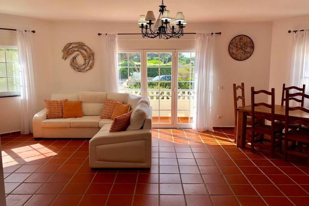 a living room with a couch and a table at Golf, Beach & Pool House in Amoreira