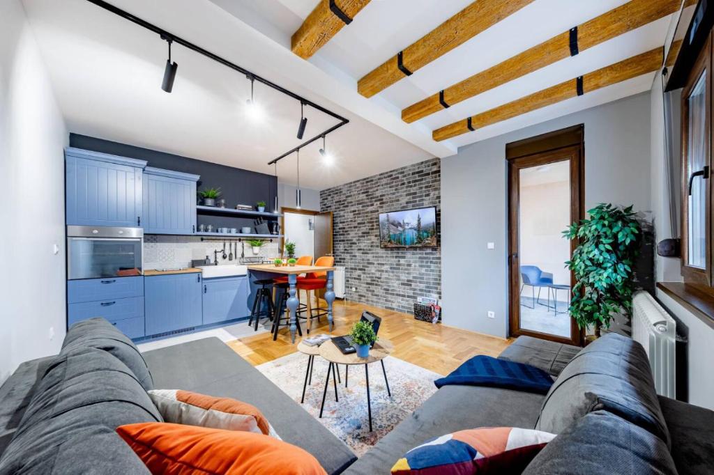 a living room with a couch and a kitchen at Apartment ERAK HILL in Zlatibor