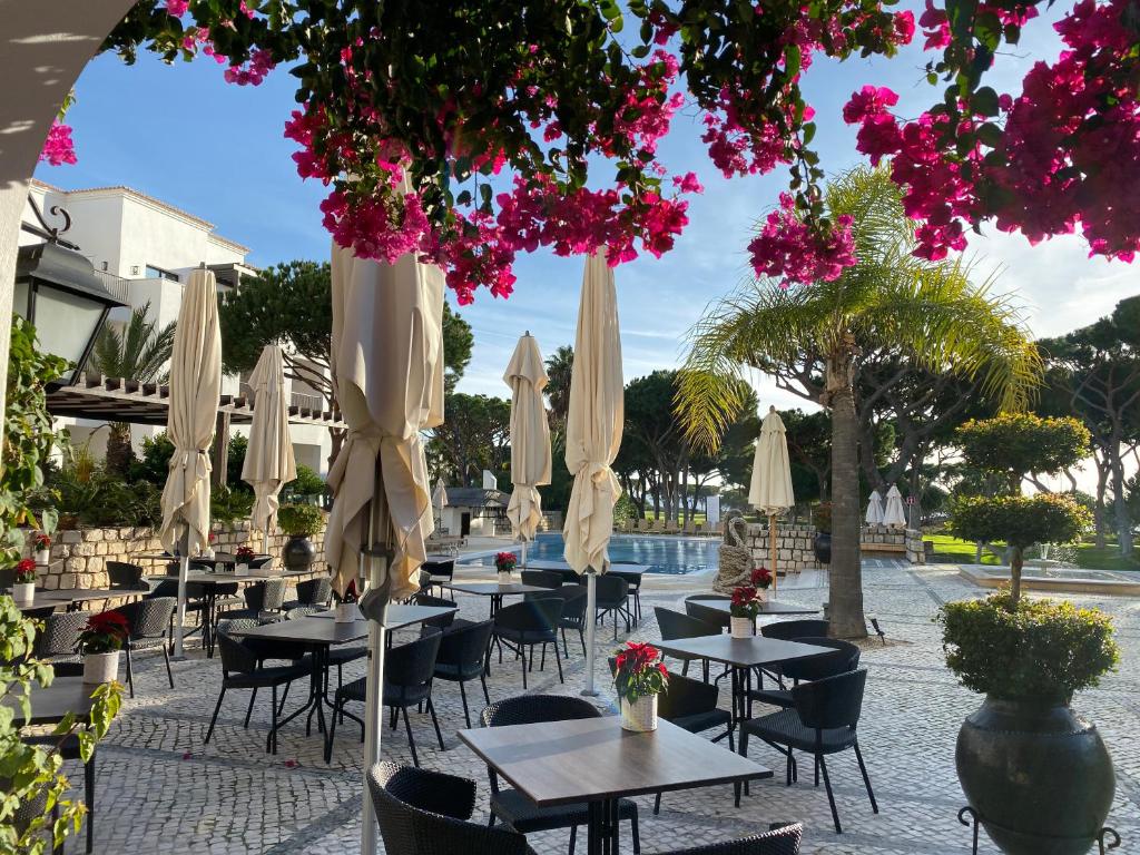 a group of tables and chairs with umbrellas at Algarve Luxury Experience - Situated within the Pinecliffs Resort in Albufeira