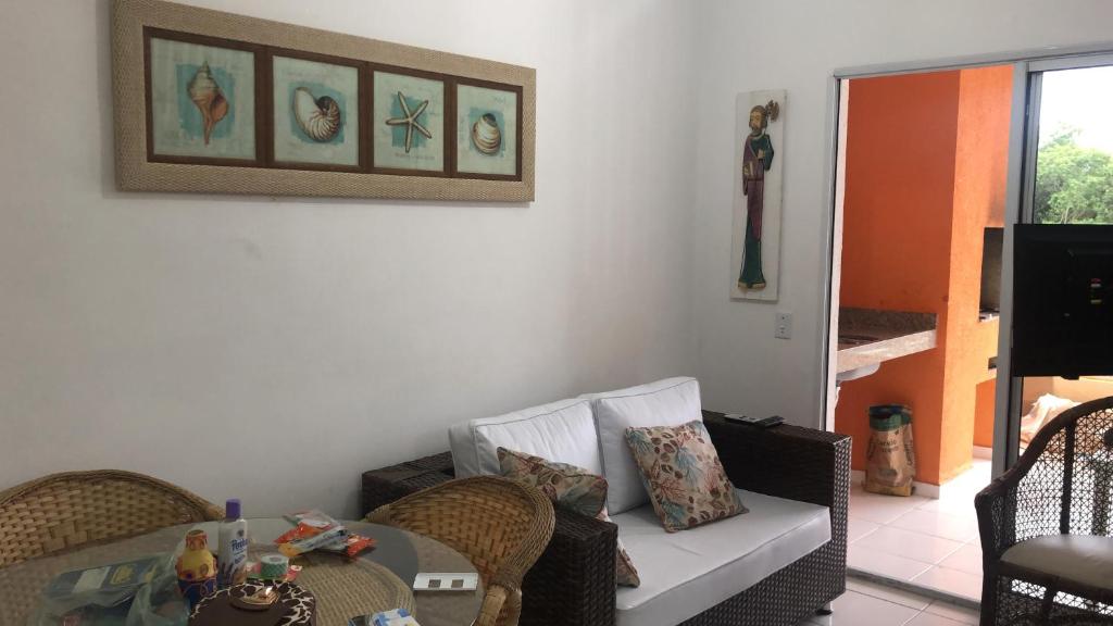 a living room with a couch and a table at Apto Praia Bertioga - 3 dormitorios sendo uma suite in Bertioga
