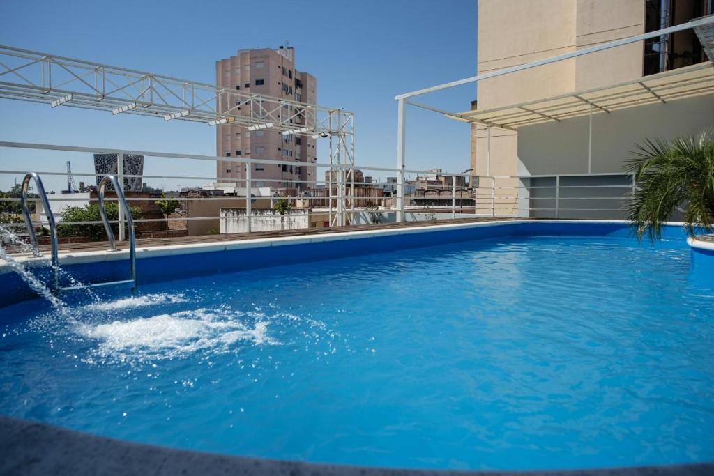 una gran piscina azul en la parte superior de un edificio en Santiago Hotel en Córdoba