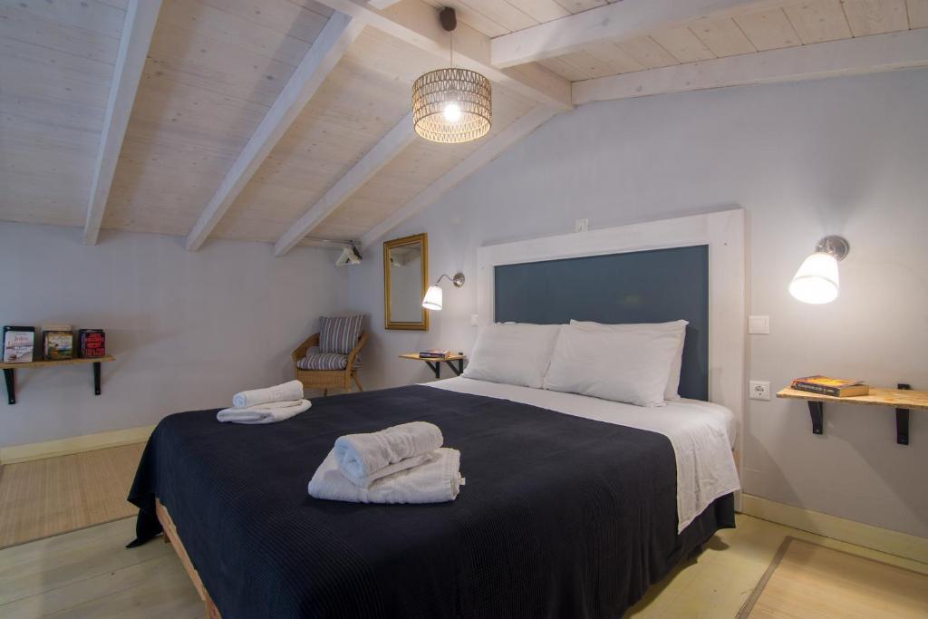 een slaapkamer met een groot bed en handdoeken bij Villa Elaia Suites & Apartments No.7 in Gaios