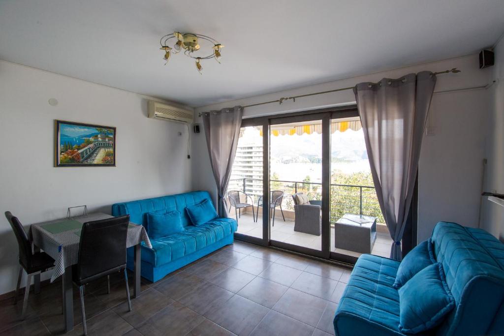 uma sala de estar com um sofá azul e uma mesa em The Blue Apartments em Budva