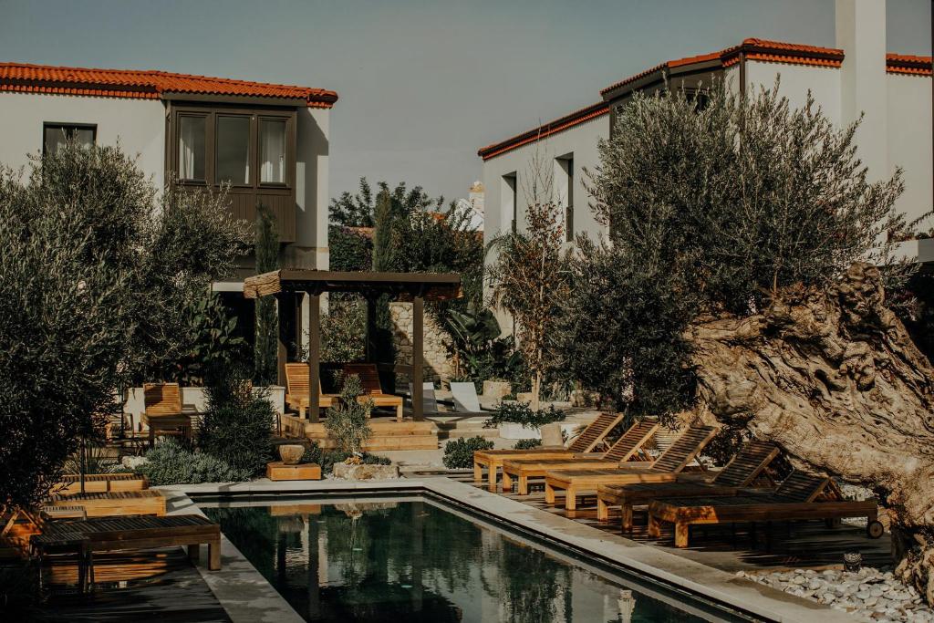 a swimming pool with chairs and a house at Bernadet Alaçatı in Alaçatı