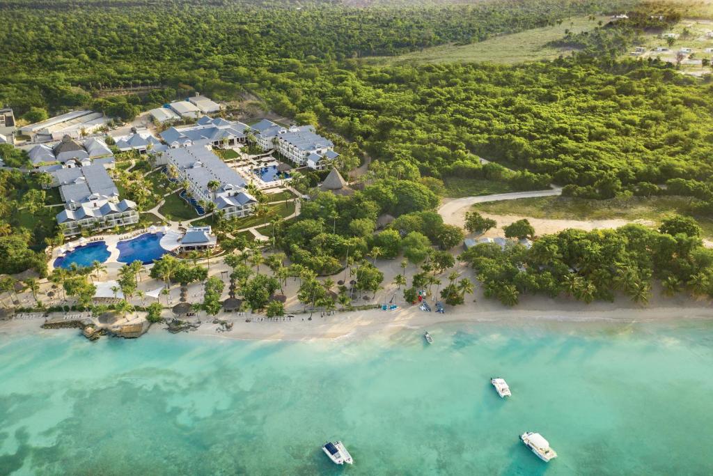 an aerial view of a resort with boats on the beach at Hilton La Romana All- Inclusive Adult Resort & Spa Punta Cana in Bayahibe