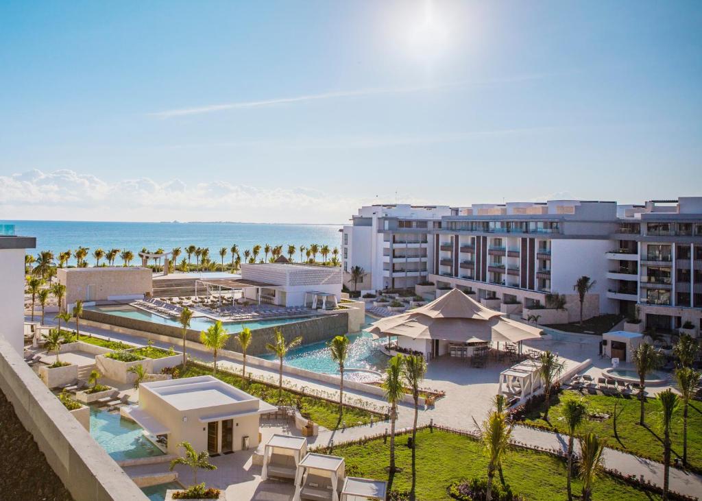 an aerial view of a resort with a pool and the ocean at Majestic Elegance Costa Mujeres - All Inclusive in Cancún