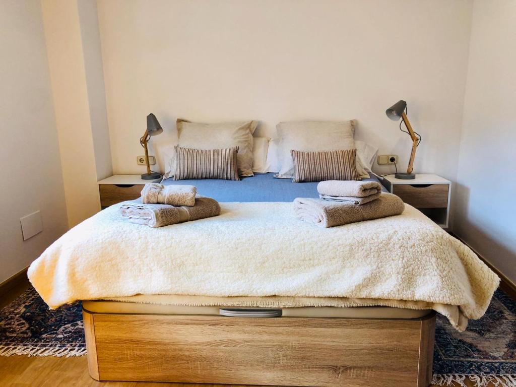 a bedroom with a large bed with two pillows on it at Cases de Canillo-Casa Sant Serni in Canillo