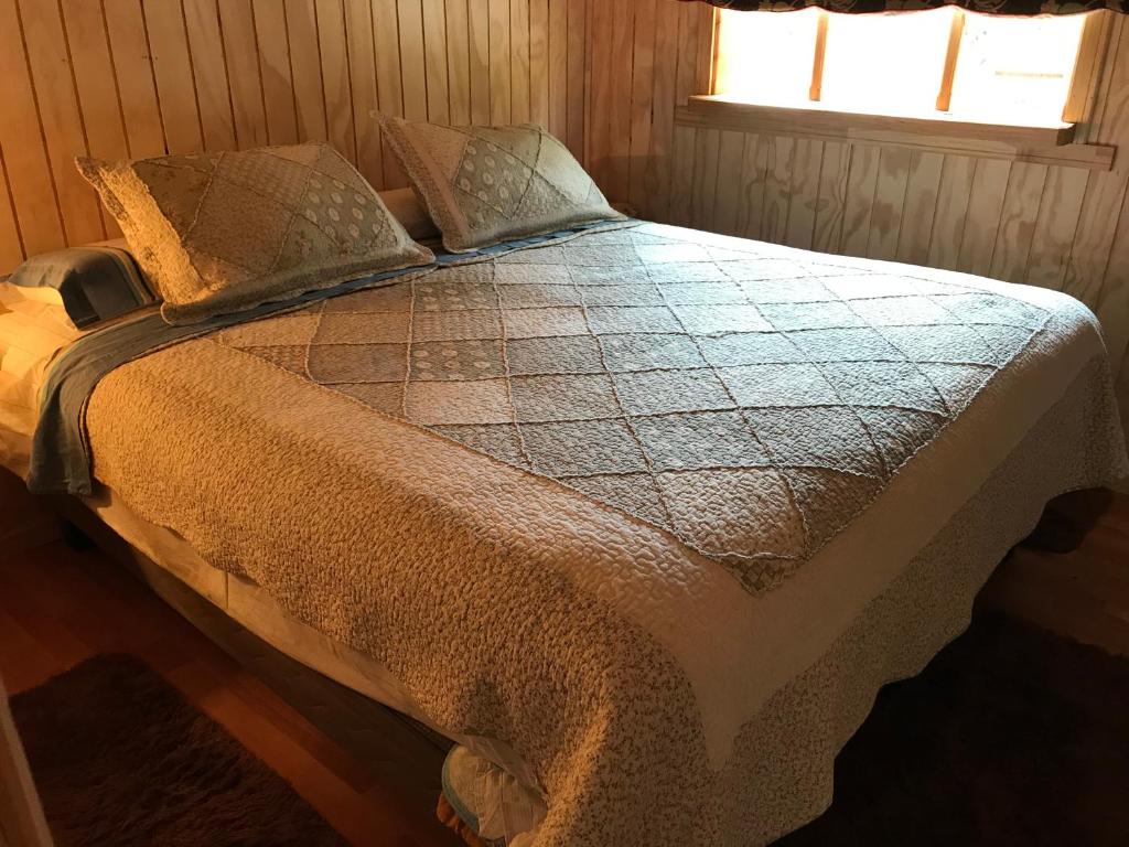 a large bed in a room with a window at Doña Marta del Truful in Melipeuco