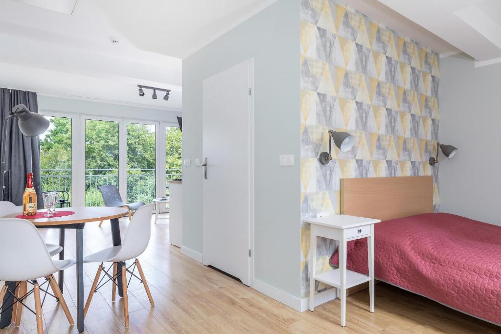 Bedroom corner with wooden headboard, patterned wallpaper, adjacent dining table and balcony light