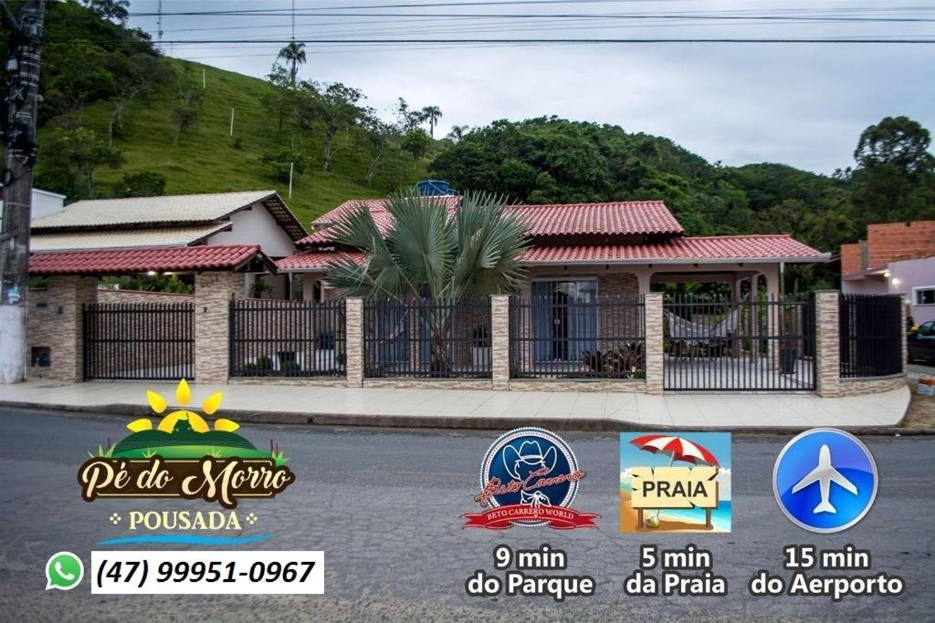 un montage d'une maison avec des panneaux devant elle dans l'établissement Pé do Morro Pousada, à Penha