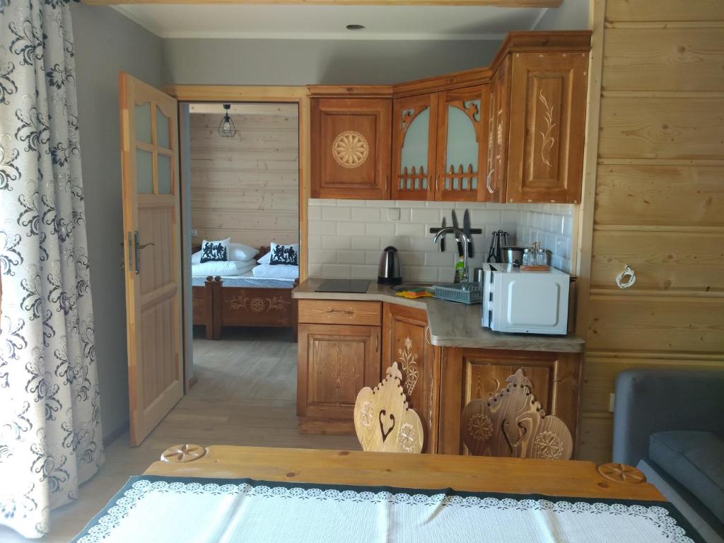 a kitchen with wooden cabinets and a counter top at Apartamenty Na Polanie in Witów