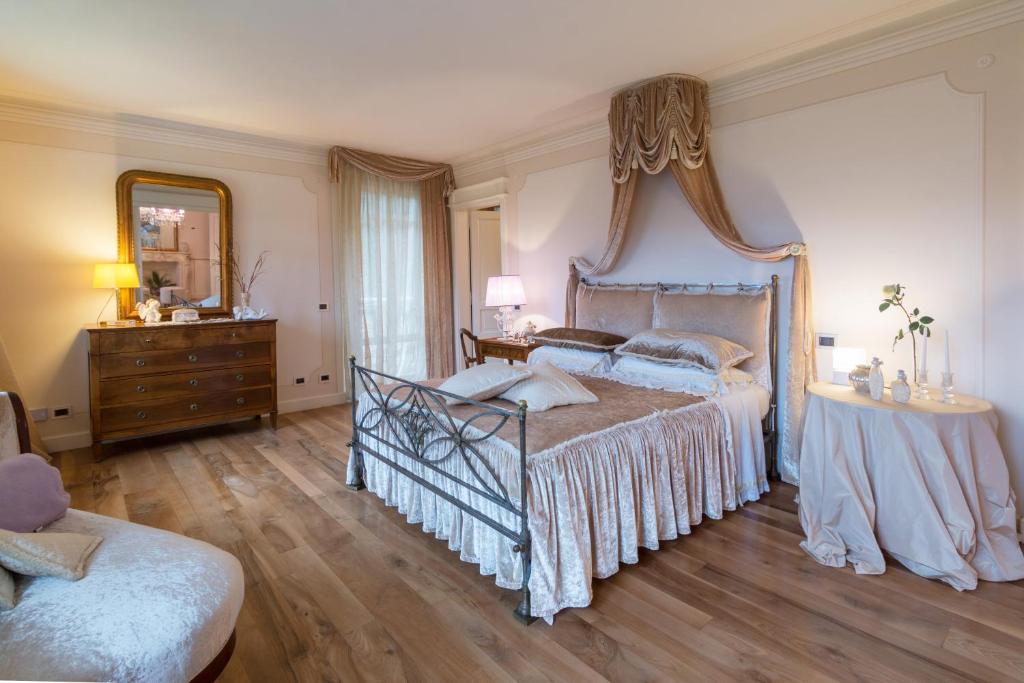 sypialnia z łóżkiem, komodą i lustrem w obiekcie Villa Caiano - Luxury In Tuscany w mieście Londa