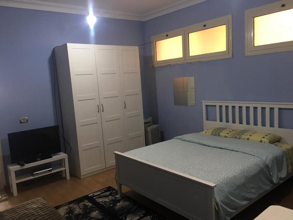 - une chambre avec un lit et une télévision dans l'établissement A studio / private room in New Cairo, au Caire