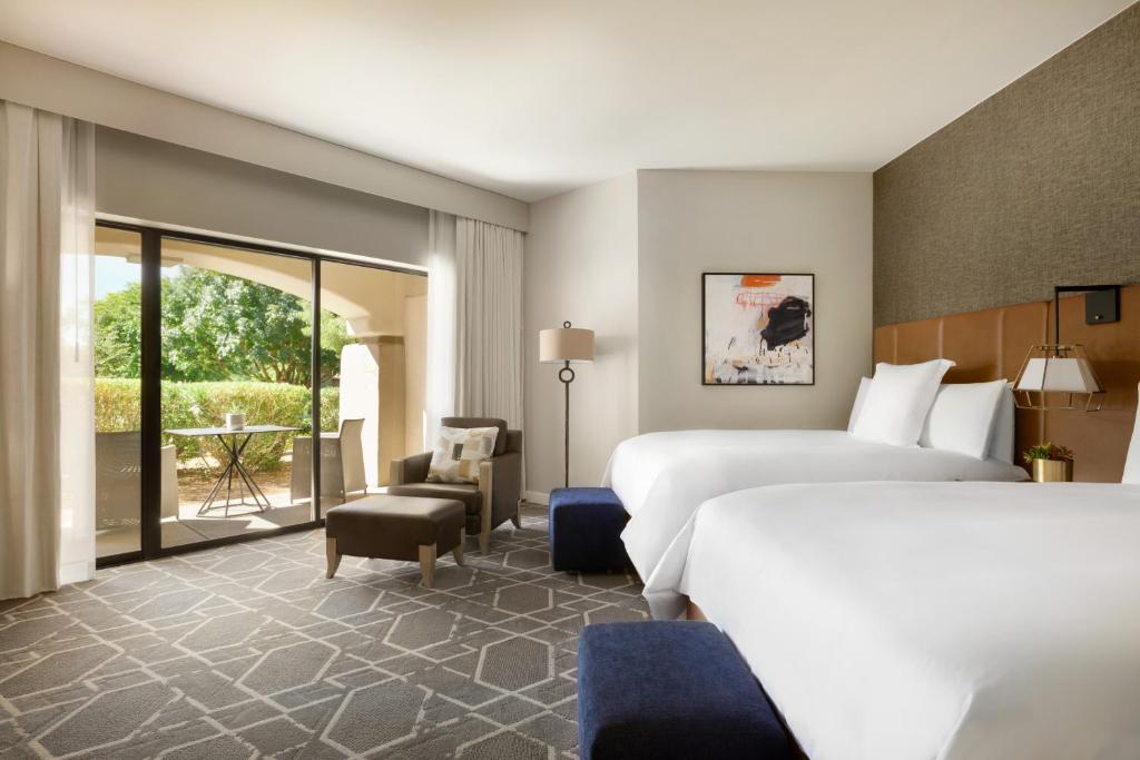 a hotel room with a large bed and a large window at Fairmont Scottsdale Princess in Scottsdale