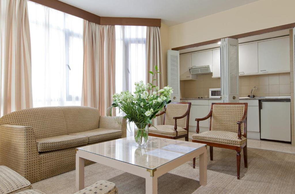 a living room with a vase of flowers on a table at Espahotel Plaza Basílica in Madrid