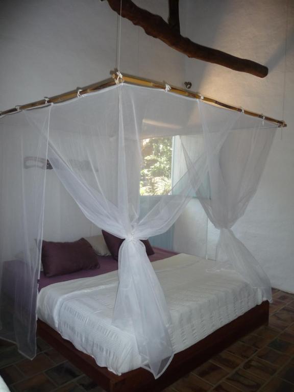a bedroom with a bed with a mosquito net at Posada Finca San Vicente B&B in Barichara