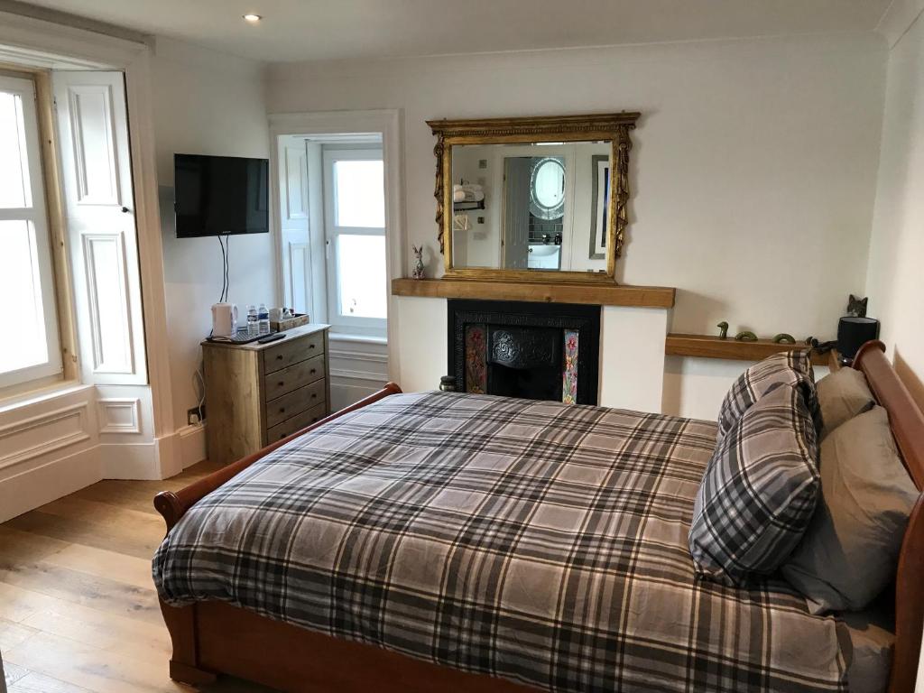 a bedroom with a bed with a fireplace and a mirror at Fasgadh Rooms in Tarbert
