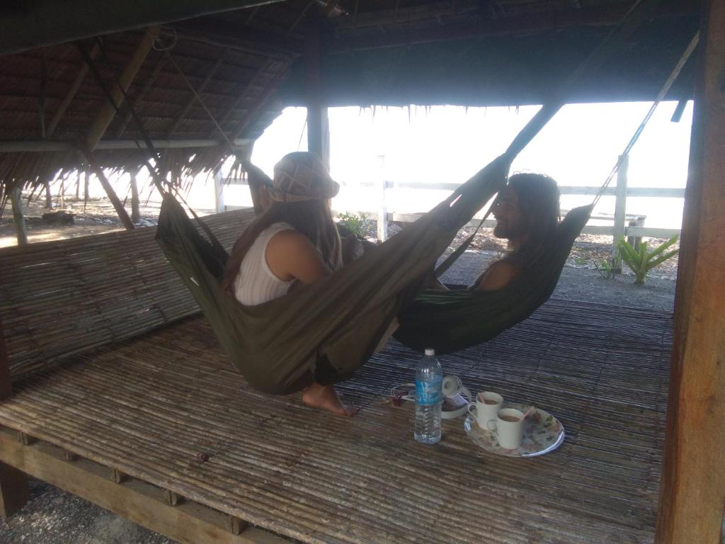 two women sitting in hammocks on a porch at Tammoyo Place in Kudat